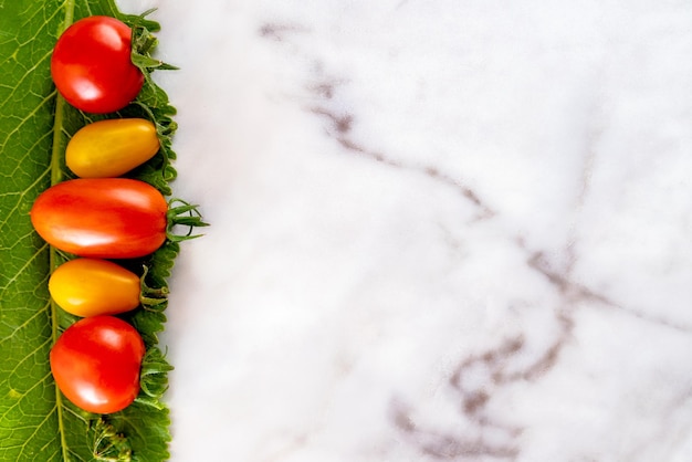 diferentes tipos de tomates en una mesa de mármol, espacio para texto, fondo, puesta plana