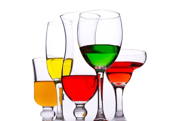 Diferentes tipos de vasos de cristal con líquido de colores en el interior.