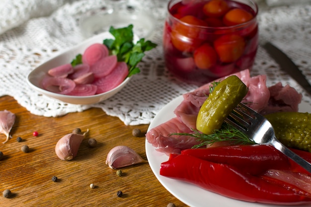 Diferentes tipos de verduras en escabeche. Pepinos en escabeche, tomate, repollo, pimiento, verduras, cebolla y ajo servidos en una mesa de estilo antiguo