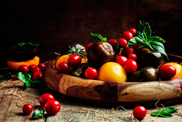 Diferentes tomates multicoloridos Foco seletivo de fundo de madeira vintage