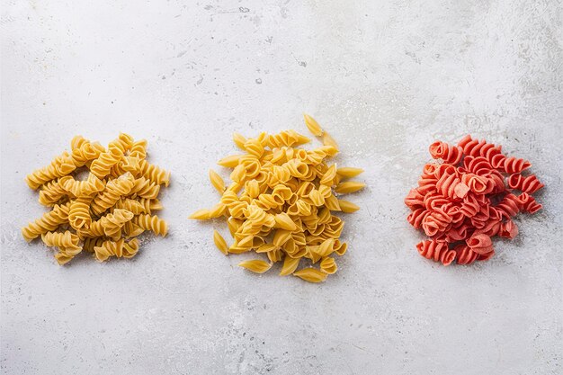 Diferentes variedades de pasta coloridas hechas a mano sobre un fondo de piedra gris