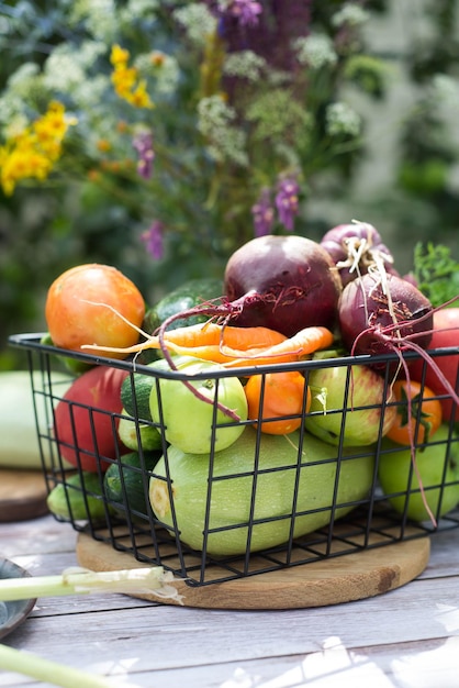 Diferentes vegetais de verão estão na cesta na mesa ao ar livre Vista superior