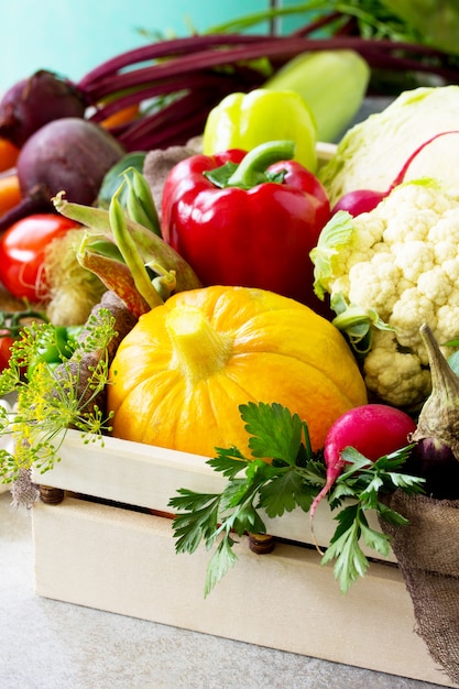 Diferentes verduras frescas en una caja de madera