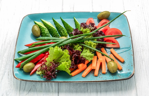 Diferentes verduras frescas en rodajas en una placa de color