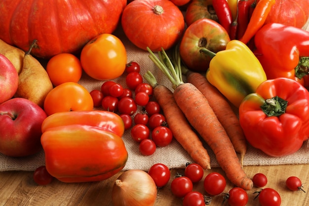 Diferentes verduras y frutas maduras frescas en primer plano de la mesa de madera
