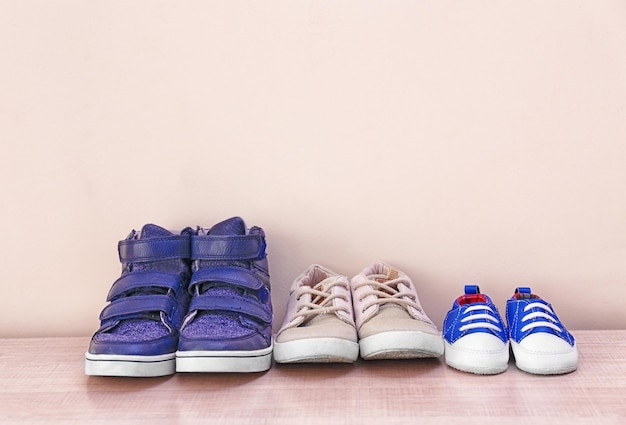 Foto diferentes zapatos de bebé sobre fondo de pared claro