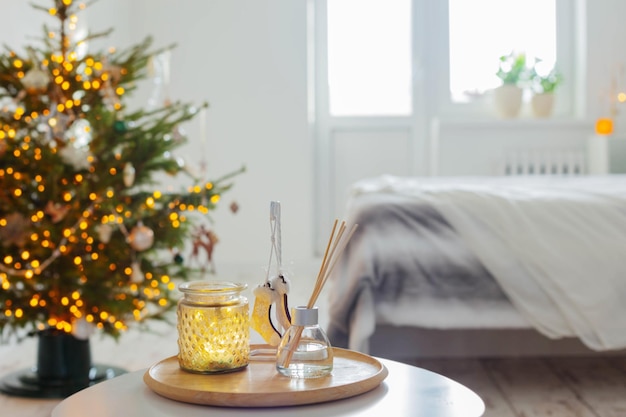 Difusor y decoración navideña en dormitorio blanco