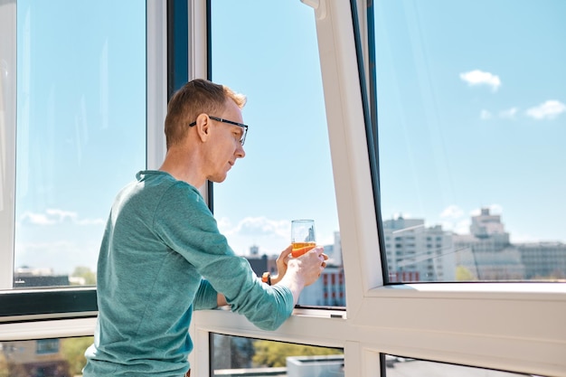 Digitaler Nomade beobachtet die Stadt vom Balkon eines Hochhauses aus