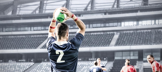 Digitales zusammengesetztes Bild des Rugbyspielers, der den Ball im Sportstadion wirft