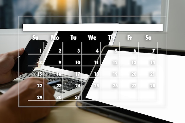 Foto digitales zusammengesetztes bild einer abgeschnittenen hand mit laptop nach kalender im büro