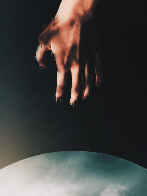 Foto digitales zusammengesetztes bild einer hand vor schwarzem hintergrund