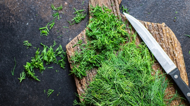 Dill frischer grüner Bund würziger Kräuter fein geschnitten mit einem Messer auf dem Tisch gesundes Essen Mahlzeit Snack