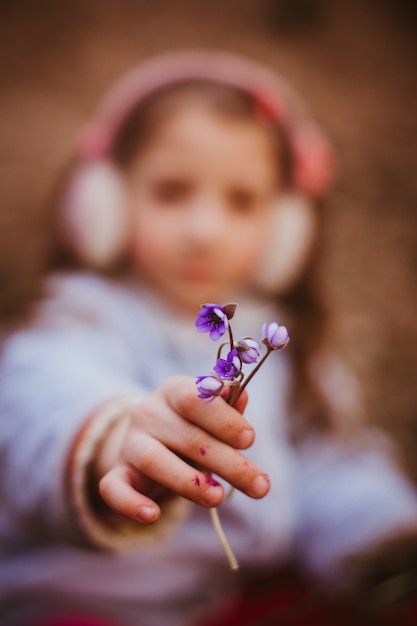 Diminutas flores violetas en el brazo de una niña pequeña