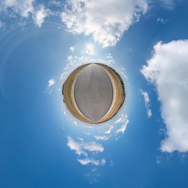 Diminuto planeta con carretera en cielo azul con hermosas nubes Transformación de panorama esférico 360 grados Vista aérea abstracta esférica Curvatura del espacio