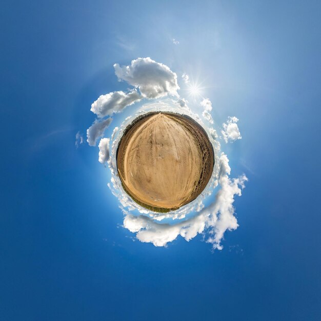 Diminuto planeta en cielo azul con sol y hermosas nubes Transformación de panorama esférico 360 grados Vista aérea abstracta esférica Curvatura del espacio