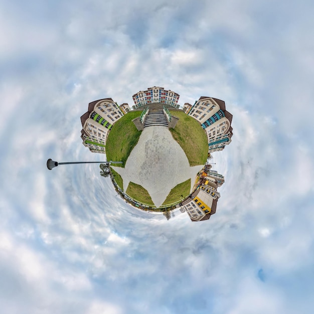 Diminuto planeta en el cielo con nubes en un moderno complejo residencial de varios pisos de desarrollo urbano Transformación del panorama esférico 360 en vista aérea abstracta