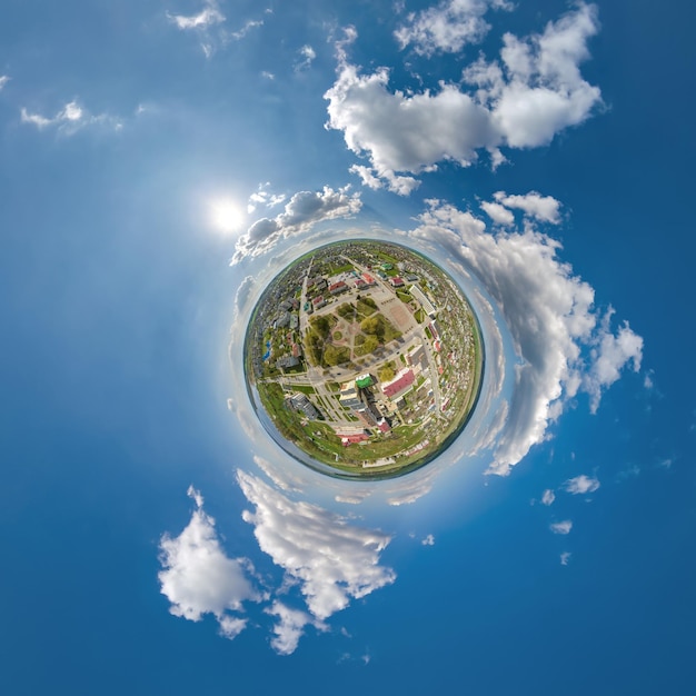 Diminuto planeta en el cielo con nubes con vistas al desarrollo urbano del casco antiguo edificios históricos y cruces Transformación del panorama esférico 360 en vista aérea abstracta