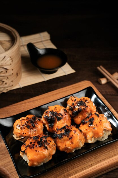Dimsum con salsa japonesa Mentai Servido en plato y palillos Enfoque seleccionado