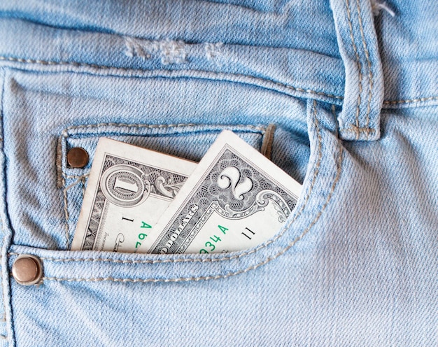 Dinero en el bolsillo de los jeans Un billete de dos dólares en el bolsillo trasero de sus jeans Dinero de bolsillo