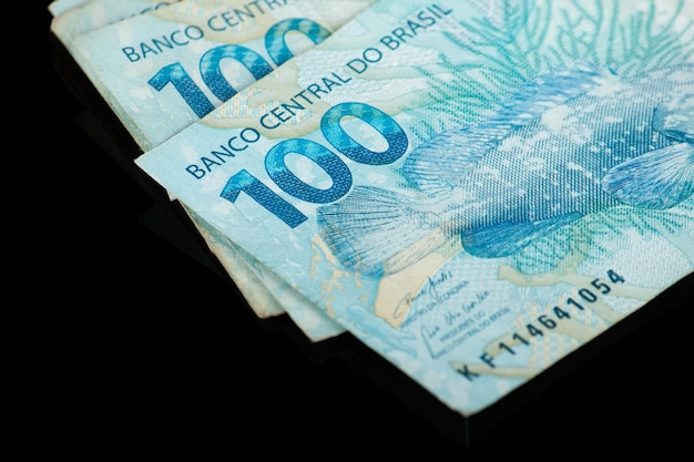 Dinero brasileño Billetes de cien reales con concepto de finanzas de fondo negro