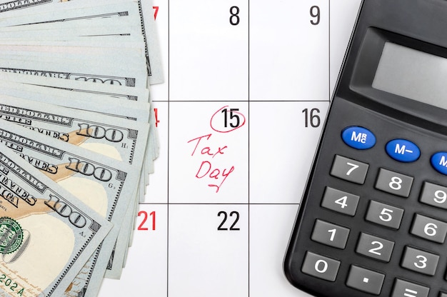 Dinero y calculadora en el calendario Día de impuestos