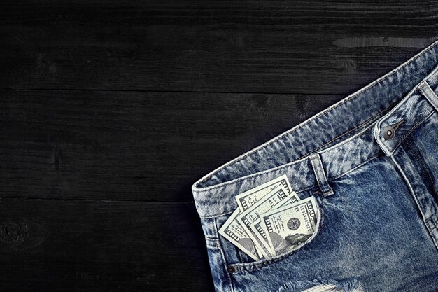 Dinero en efectivo en el bolsillo de tus jeans naturaleza muerta