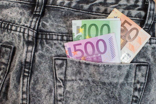 Dinero europeo en euros en el bolsillo trasero de los jeans