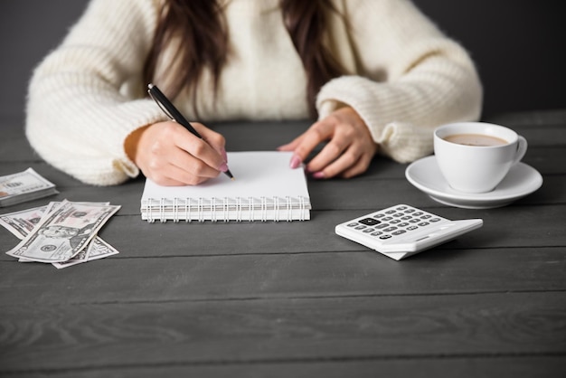 Foto dinero y libreta de mano de mujer