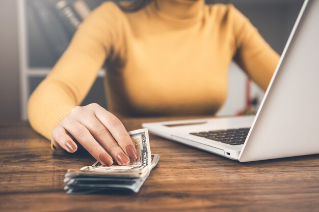 Dinero de mano de mujer con teclado en el escritorio