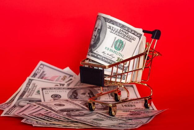 Foto dinero en moneda estadounidense dólares en un modelo de carrito de compras concepto financiero y bancario