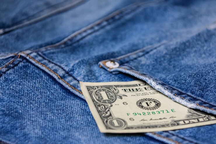 Dinero en la parte posterior de los tejanos bolsillo denim textura de fondo.