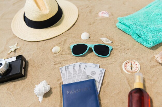 dinero en pasaportes sombras y sombrero en la arena de la playa