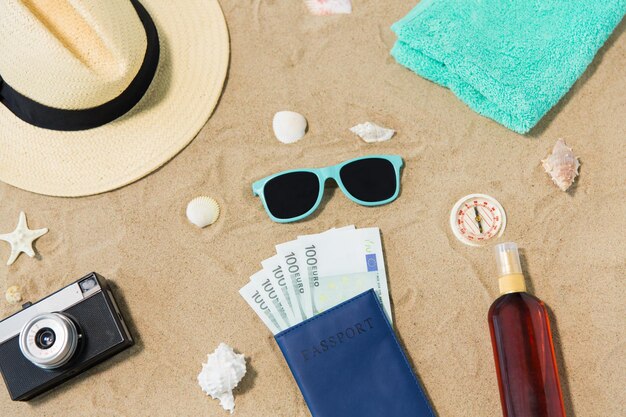 Foto dinero en pasaportes sombras y sombrero en la arena de la playa