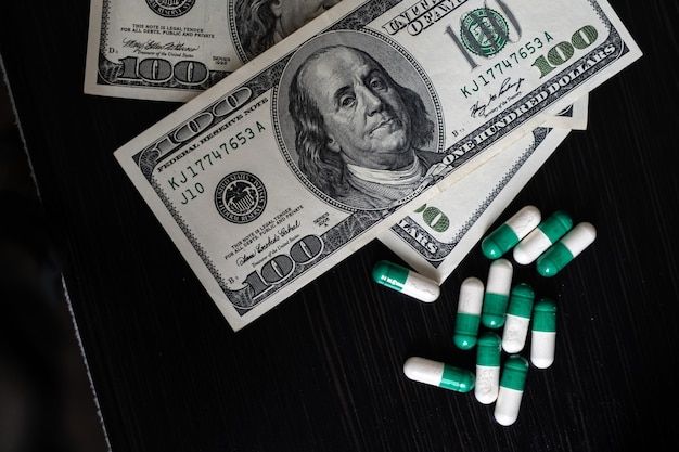 Dinero y pastillas, tabletas de pastillas para la salud, efectivo y cápsulas farmacéuticas en dólares