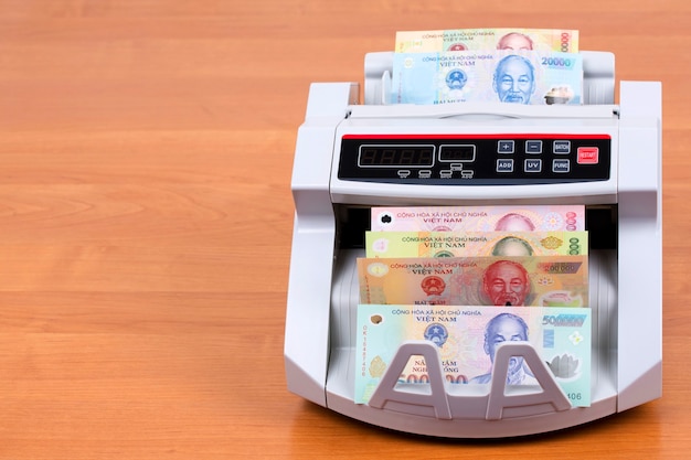 Dinero de Vietnam en una máquina contadora