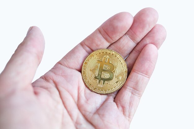 Dinero virtual oro bitcoin mujeres mano con uñas rojas dedos aislado sobre fondo blanco.