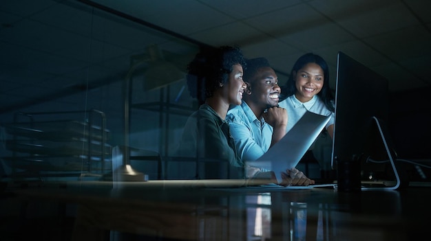 Dinge tun, die Dinge bewegen Aufnahme einer Gruppe junger Geschäftsleute, die während einer langen Nacht bei der Arbeit gemeinsam einen Computer benutzen