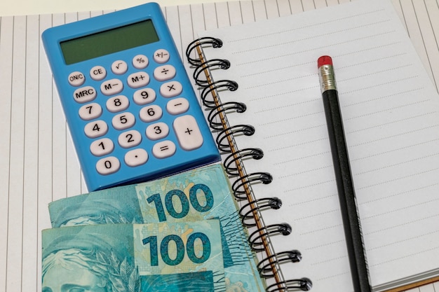 Foto dinheiro brasileiro, calculadora e bloco de notas