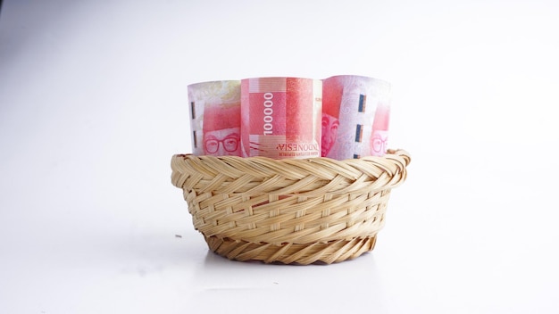 Dinheiro da rupia da Indonésia em rolos na cesta de vime Foco seletivo