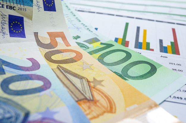Dinheiro das cédulas do euro no papel de fundo do gráfico da carta.