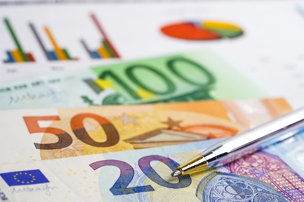 Dinheiro das cédulas do Euro no papel de fundo do gráfico da carta.