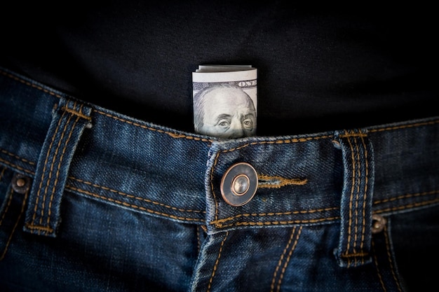 Dinheiro do dólar americano no bolso da calça jeans