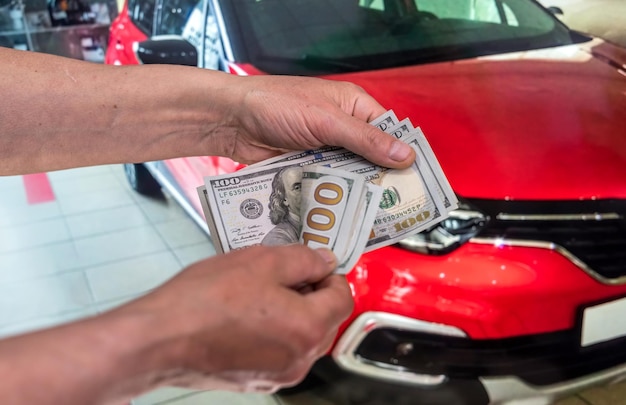 Dinheiro para comprar o carro novo. Conceito financeiro. Dólar na mão