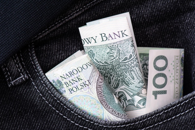 Dinheiro verde Notas de papel cem zlotys no bolso de jeans pretos Economizando armazenamento e troca de dinheiro fundo de negócios
