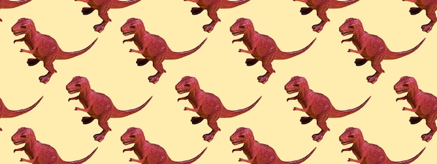 Foto dinosaurio de plástico de juguete sobre un fondo de color. concepto de patrones sin fisuras para textura, diseño, papel tapiz, decoración, textil. bandera