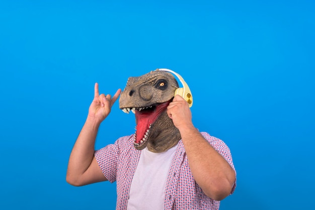 dinossauro com corpo humano ouvindo música em um fundo azul isolado