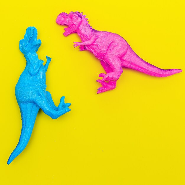 Dinossauros de dois brinquedos em um fundo colorido. Flat lay minimal art