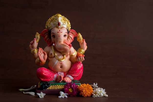 Dios hindú Ganesha. Ídolo de Ganesha en el espacio de madera oscura.