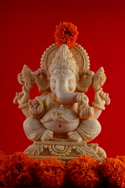 Dios hindú Ganesha. Ganesha Idol sobre fondo rojo.