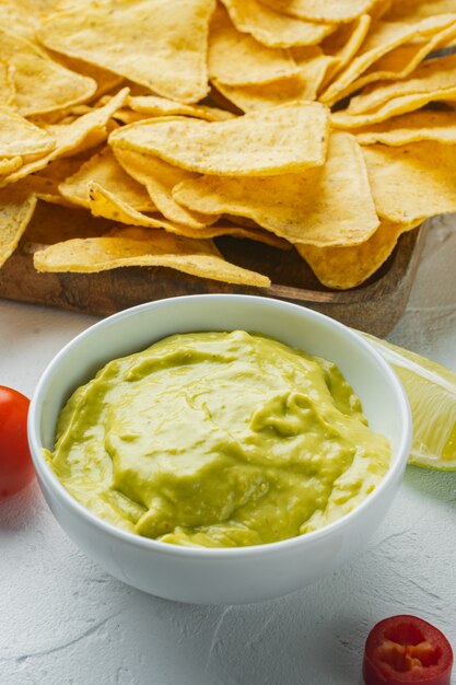 Dip de aguacate o guacamole en un tazón, sobre mesa blanca